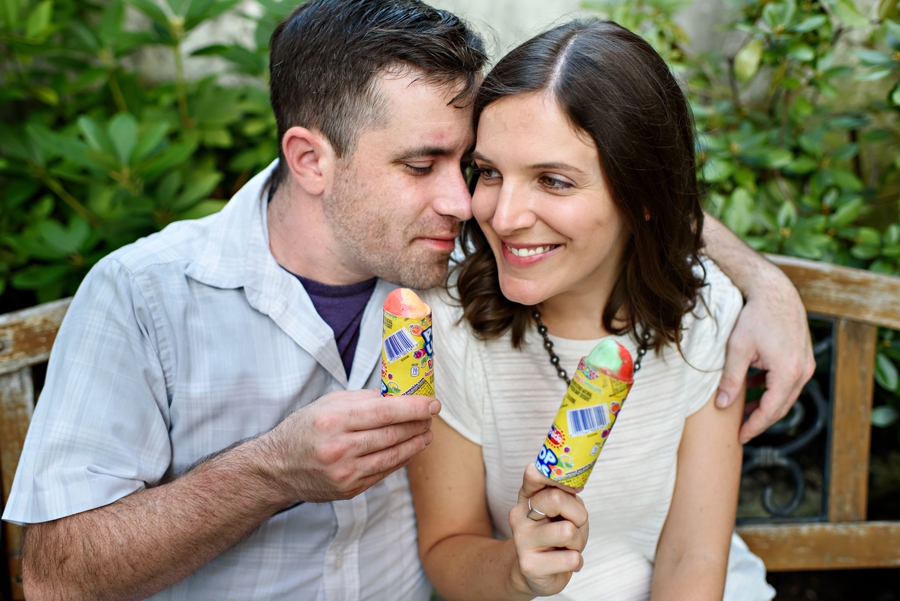 A man and woman have ice cream on a bench during their engagement session in fishtown.